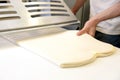 Rolling out dough by male hands at bakery Royalty Free Stock Photo