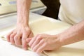 Rolling out dough by male hands at bakery Royalty Free Stock Photo