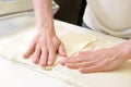 Rolling out dough by male hands at bakery Royalty Free Stock Photo