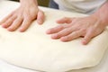 Rolling out dough by male hands at bakery Royalty Free Stock Photo