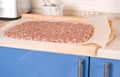 Rolling out minced beef over the kitchen Royalty Free Stock Photo