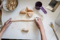 Rolling pasta dough on dusted kitchen counter to make homemade noodles and gnocchi