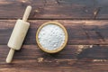 Rolling pin and flour on wooden background. Top view with copy space