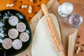 Rolling pin with a mustache pattern on a wooden decorated table covered with baked flour. Rolled dough with a pattern and cookie o