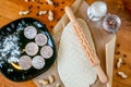 Rolling pin with a mustache pattern on a wooden decorated table covered with baked flour. Rolled dough with a pattern and cookie o