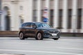 Rolling shot of black color EV crossover car, front side view. Voyah free electric SUV driving along the street in city with Royalty Free Stock Photo