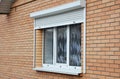 Rolling shutters brick house windows protection. Brick house with metal roller shutters on the windows
