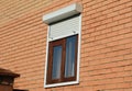 Rolling shutters house windows protection. Brick house with metal roller shutters on the windows Royalty Free Stock Photo