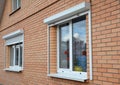 Rolling shutters house windows protection. Brick house with metal roller shutters on the windows Royalty Free Stock Photo