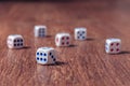 Rolling three dice on a wooden desk Royalty Free Stock Photo