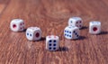 Rolling three dice on a wooden desk Royalty Free Stock Photo
