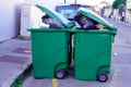 Rolling trash can green home rubbish wheelie bins full in street Royalty Free Stock Photo