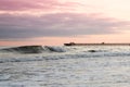 Rolling waves under sunset with Pier. Royalty Free Stock Photo