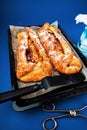 2 rolls of apple pie strudel on pan, tongs and sugar Royalty Free Stock Photo