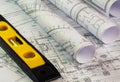 rolls of architecture blueprints and technical drawings with yellow building level, close up Royalty Free Stock Photo