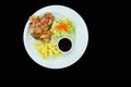 Rolls of bacon and chicken steak with French fries and red sauce and salads