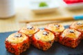 Rolls in a black plate on a wooden table. Fried sushi on black slate surface. Japanese food Royalty Free Stock Photo