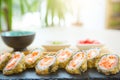 Rolls in a black plate on a wooden table. Fried sushi on black slate surface. Japanese food Royalty Free Stock Photo