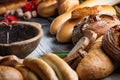 Rolls and breads on wooden table with wooden bowl, background for bakery or market Royalty Free Stock Photo