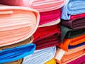 Rolls of bright multicolored fabric close-up. Many different fabrics are rolled up and lying on the shelves. Samples of different Royalty Free Stock Photo
