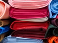 Rolls of bright multicolored fabric close-up. Many different fabrics are rolled up and lying on the shelves. Samples of different Royalty Free Stock Photo