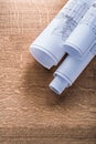 Rolls of construction plans on wooden oaken board Royalty Free Stock Photo