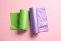 Rolls of different garbage bags on pink background, flat lay Royalty Free Stock Photo