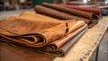 Rolls of diverse leather types are neatly arranged on a wooden table Royalty Free Stock Photo