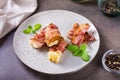 Rolls of fried bacon and mashed potatoes and basil on a plate on the table Royalty Free Stock Photo