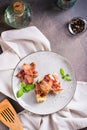 Rolls of fried bacon and mashed potatoes and basil on a plate on the table. Top and vertical view Royalty Free Stock Photo