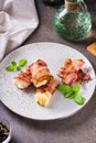 Rolls of fried bacon and mashed potatoes and basil on a plate on the table. Vertical view Royalty Free Stock Photo