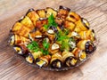 Rolls of fried eggplant stuffed with tomatoes, mayonnaise and garlic on a wooden background