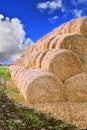 Rolls of hay stacked in a stack on the field against the blue sky Royalty Free Stock Photo