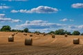 Rolls haystacks straw on field, harvesting wheat. Rural field with bales of hay.