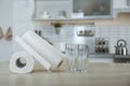 Rolls of paper towels and glasses on table in kitchen Royalty Free Stock Photo