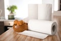 Rolls of paper towels with tasty pastry on kitchen table