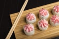 Rolls with pink lava sauce on a bamboo board. Serving Japanese food on a wooden table