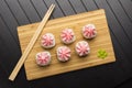 Rolls with pink lava sauce on a bamboo board. Serving Japanese food on a wooden table