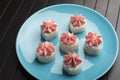 Rolls with pink lava sauce on a blue plate, on a wooden table. Serving Japanese food