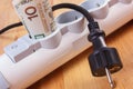 Rolls of polish currency money in electrical power strip and disconnected plug, energy costs Royalty Free Stock Photo