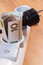 Rolls of polish currency money in electrical power strip and disconnected plug, energy costs Royalty Free Stock Photo