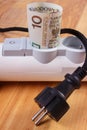 Rolls of polish currency money in electrical power strip and disconnected plug, energy costs Royalty Free Stock Photo