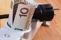 Rolls of polish currency money in electrical power strip and disconnected plug, energy costs Royalty Free Stock Photo