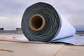 Rolls of polymer coating for roof. Deployment of a roof covering roll Royalty Free Stock Photo