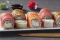 Rolls set with salmon, tuna and smoked eel with philadelphia cheese on white plate on gray background. Served with soy Royalty Free Stock Photo