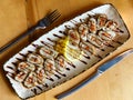 Rolls of thin pancakes with smoked salmon, cream cheese on plate on wooden table with fork and knife. Top view Royalty Free Stock Photo