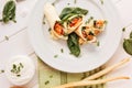 Rolls of thin pancakes with smoked salmon, horseradish cream cheese and spinach leaves. Side view with copy space Royalty Free Stock Photo