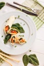 Rolls of thin pancakes with smoked salmon, horseradish cream cheese and spinach leaves. Side view with copy space Royalty Free Stock Photo