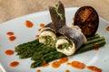 Rolls of white baked fish with asparagus sauce