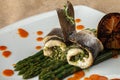 Rolls of white baked fish with asparagus sauce